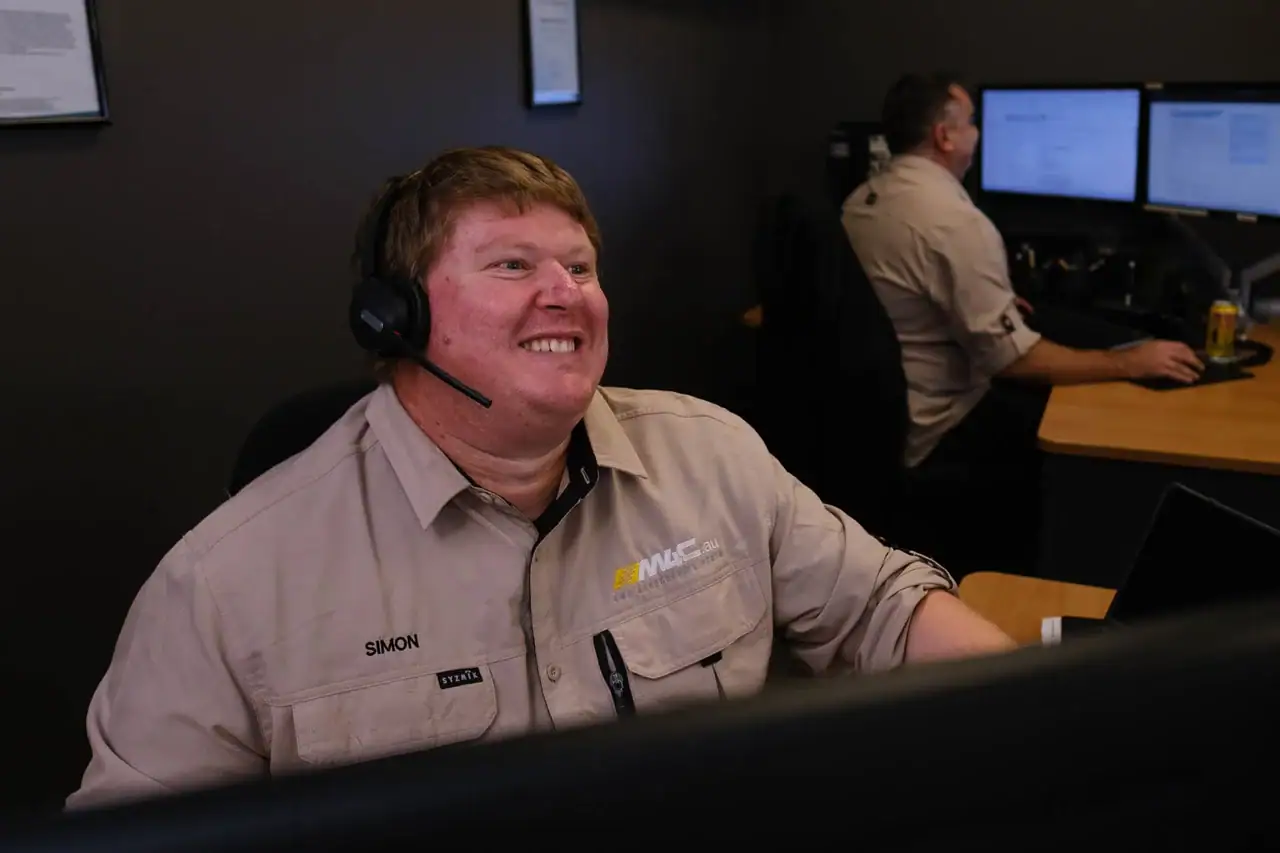 One of the M4C team on a headset at the Canning Vale sales desk, a second at the workstation behind