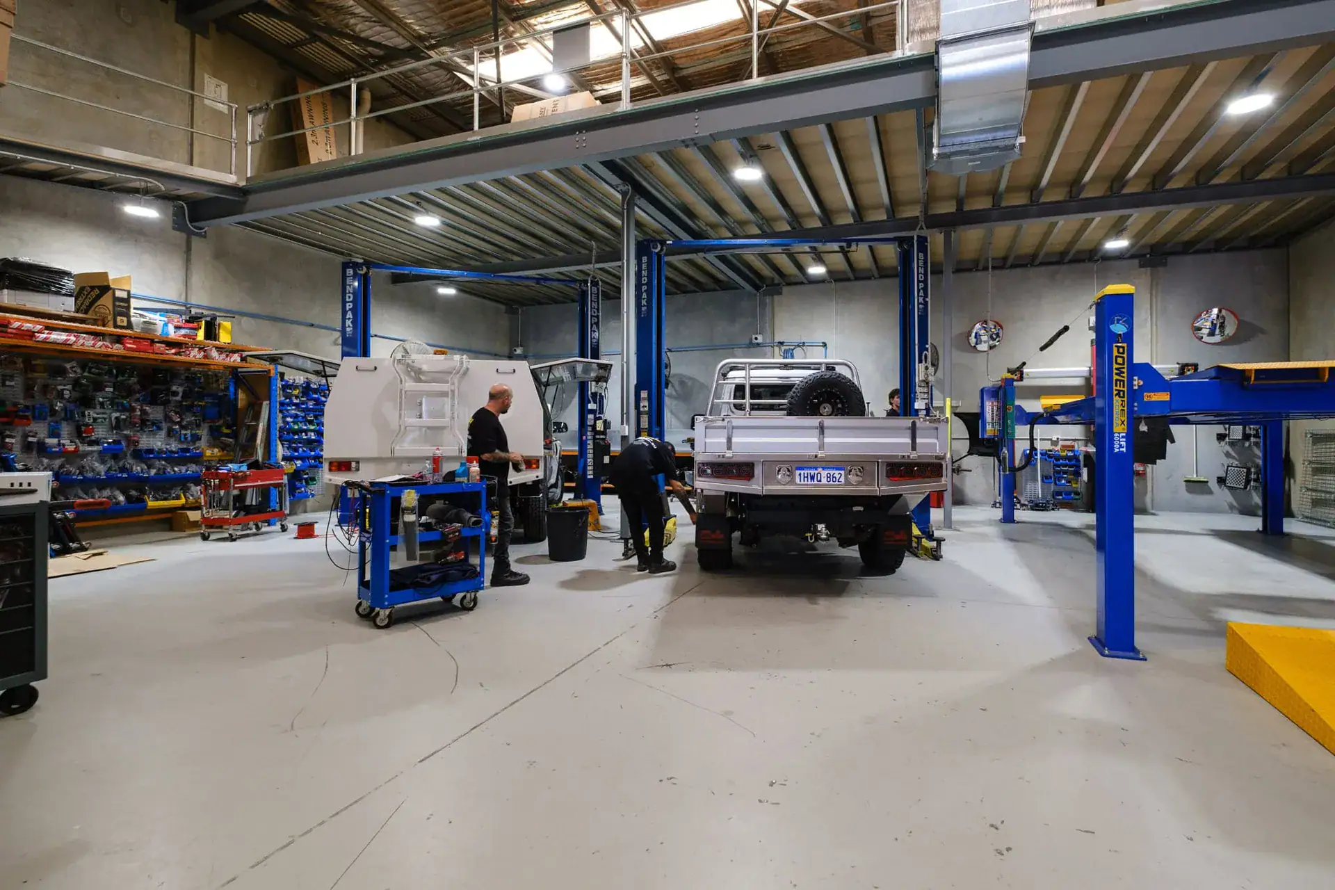 Inside the M4C workshop in Canning Vale, a 4WD on the hoist